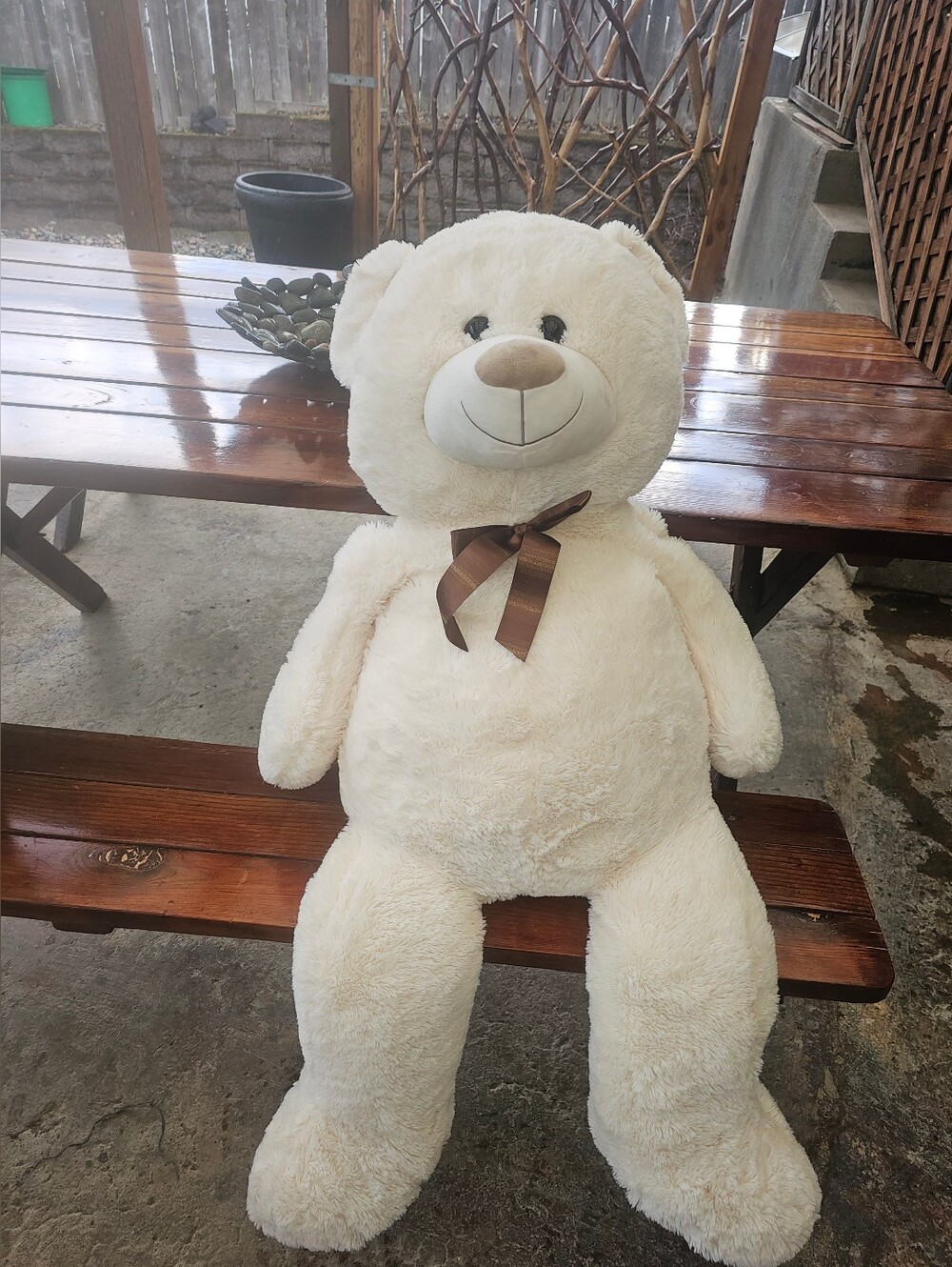giant white teddy bear with a brown bow
